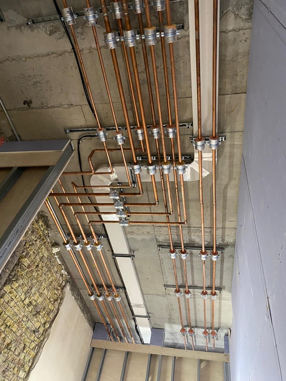 Copper riser pipework run and bracketed services first fix